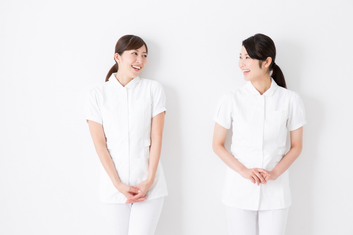 笑顔で向き合う2人の女性看護師